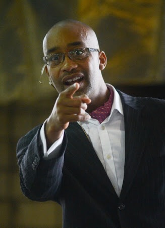 Dr. Jarik Conrad speaking and gesturing toward the audience